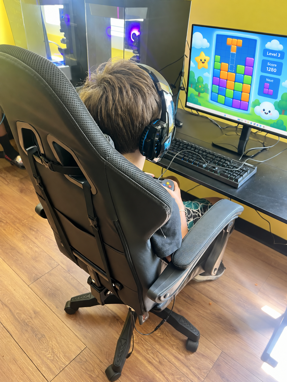 A young participant wearing headphones at a Building Blocks gaming station